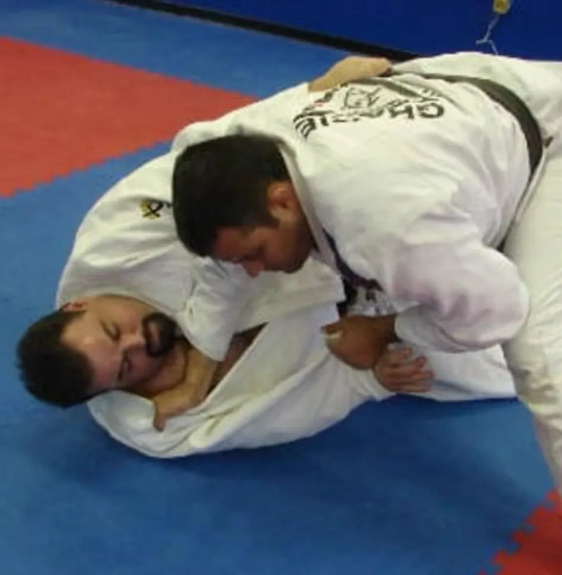 Master Rocian Gracie Jr and Professor Konrado grappling in the gi